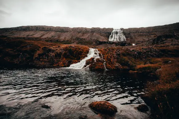Shot of Dynjandi waterfall along with another smaller waterfall into a dark pool.